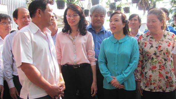 Health Minister Nguyen Thi Kim Tien (blue T-shirt) speaks to residents about dengue fever prevention (Photo: SGGP)